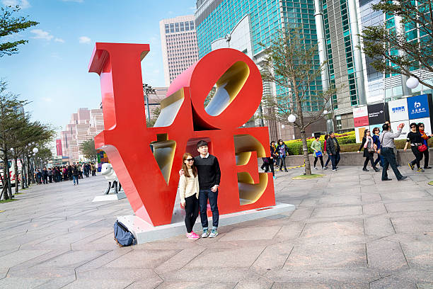 Taipei, Taiwan - Jan 5, 2015: Tourists posing for picture at the entrance of Taipei 101. Taipei 101 one of the main tourists attraction in Taiwan.