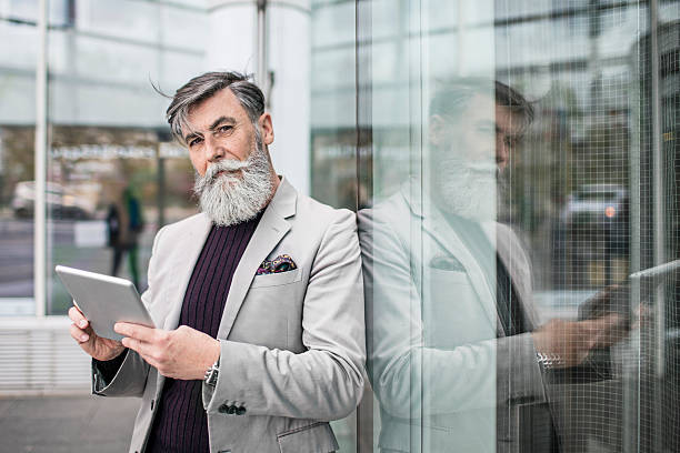 Portrait of a senior businessman using digital tablet Portrait of a senior businessman using digital tablet. stars in your eyes stock pictures, royalty-free photos & images
