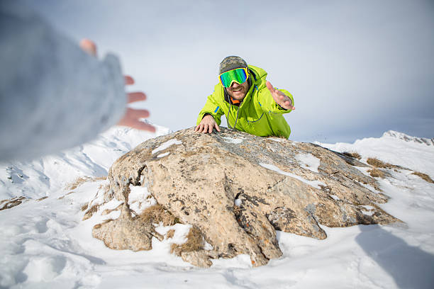 istock Man offering helping hand on mountain top-Winter 532357557