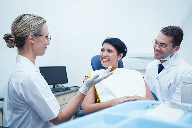 istock Male dentist and assistant with female patient 532371793