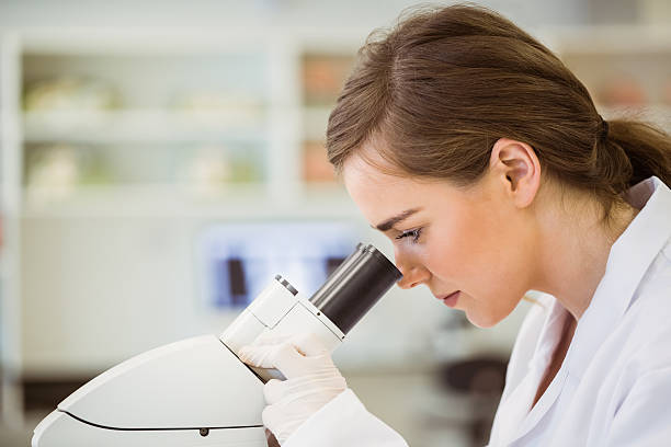 Young scientist working with microscope Young scientist working with microscope at the university scientific exploration stock pictures, royalty-free photos & images