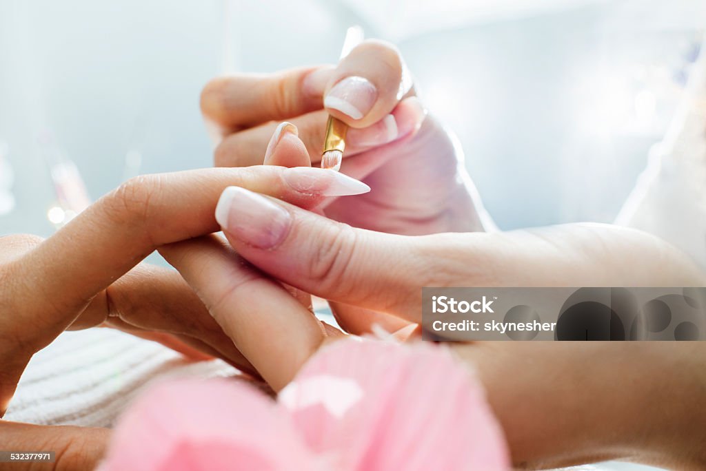 Manicure. Close up of applying nail polish on the customer's nail. Beauty Spa Stock Photo