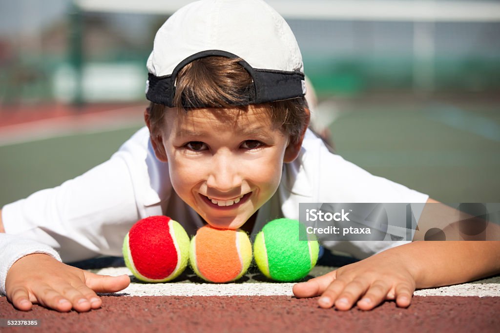Mini tennis player Happy little boy with different colored balls for mini tennis - red, orange and green Tennis Stock Photo
