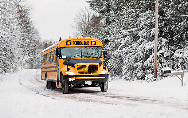 School Bus Driving Down A Snow Covered Road