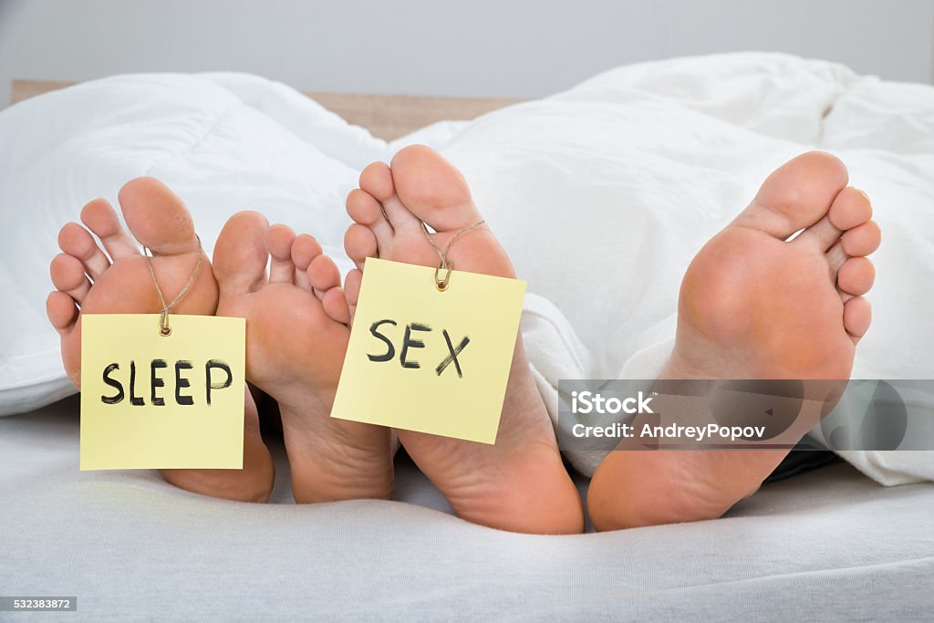 Four Feet With The Text Sleep And Sex On Label Close-up Of Four Feet With The Text Sleep And Sex On Label In Bed Adult Stock Photo