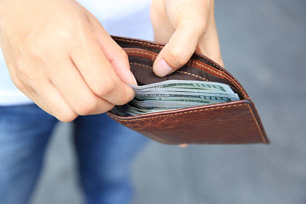 istock Hands taking  us dollars  out from wallet on the street 532385062