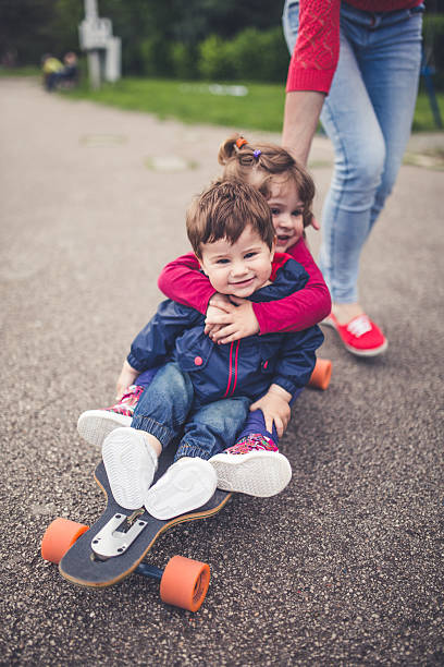 istock Playful brother and sister on skateboard 532387026