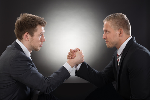 Close-up Of Two Young Businessman Competing In Arm Wrestling