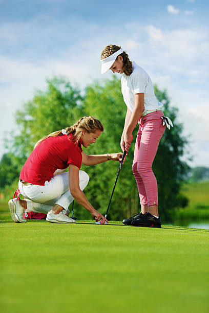 istock Trainer works with children at golf school 532391958