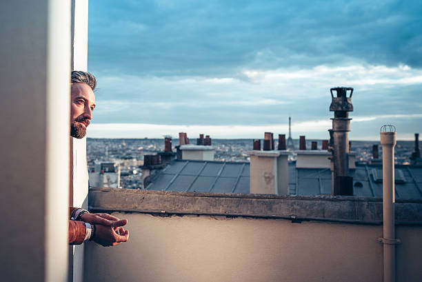 istock side view on man looking over the roofs of Paris 532392112