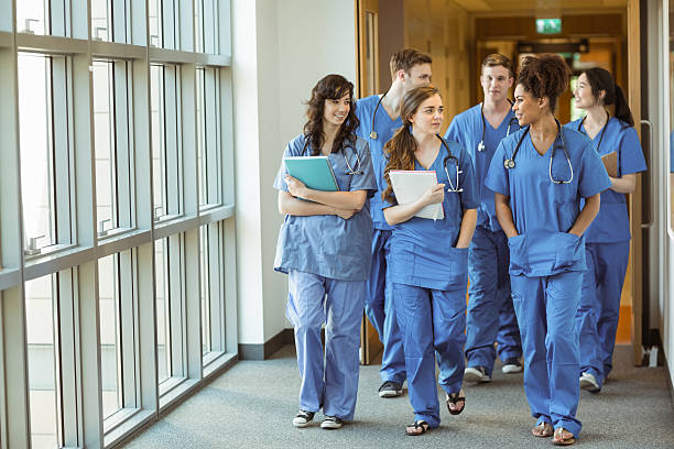 Medical students walking through corridor stock photo