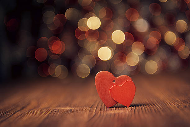 istock Red heart on wooden board against defocused lights 532395033