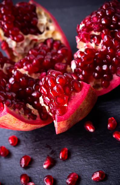istock Some red pomegranates on black slate plate 532395051