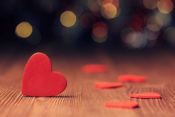 istock Red heart on wooden board against defocused lights 532395517