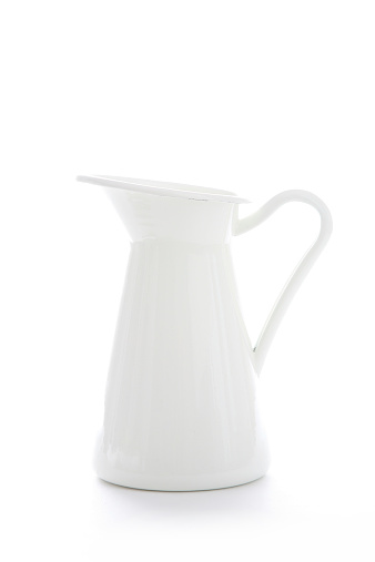 Enamelled metal jug on white background