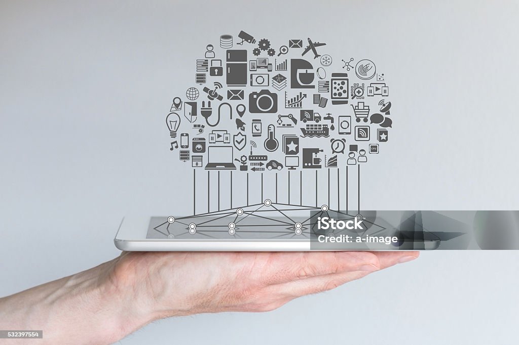 Tablet with cloud of connected devices for internet of things Hand holding tablet or modern smart phone with cloud of connected devices for internet of things and smart home automation. Internet of Things Stock Photo
