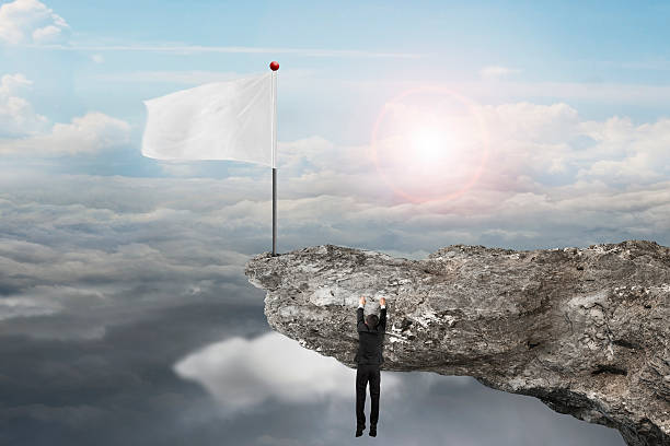 istock man hanging on cliff with blank flag and sunlight cloudscapes 532400343