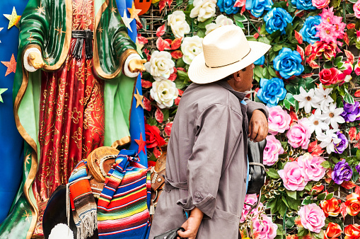 Mexico City, Mexico - March 30, 2013: Man with a camera by bright colorful flowers on Tepeyac Hill in Mexico City on March 30, 2013