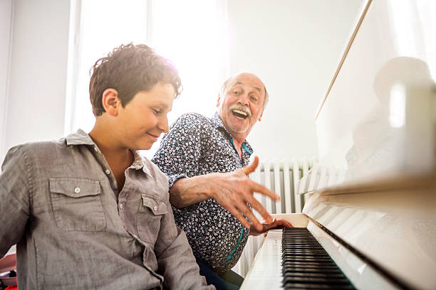 istock Little boy playing piano with his grandfather 532403926