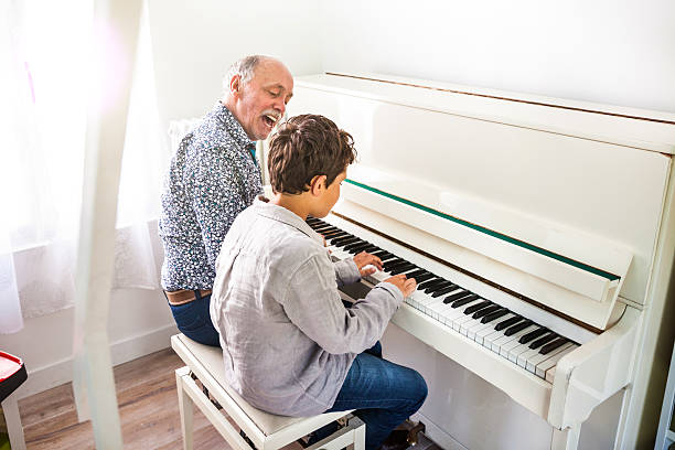 istock Little boy playing piano with his grandfather 532404164