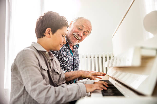 istock Little boy playing piano with his grandfather 532404730
