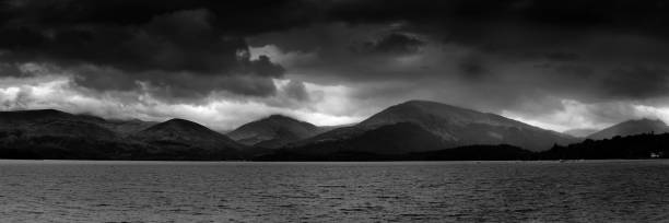 A moody black and white image showing Loch Lomond just before a storm.