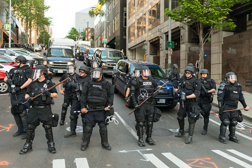 Seattle, USA - May 1, 2016: Seattle Police officers in riot gear clash with protestors in the annual Anti-Capitalist Protest on 3rd avenue Late in the day.