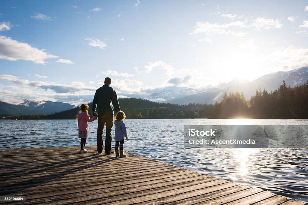 Father and daughter connection Father and daughters bonding by the lake Family Stock Photo