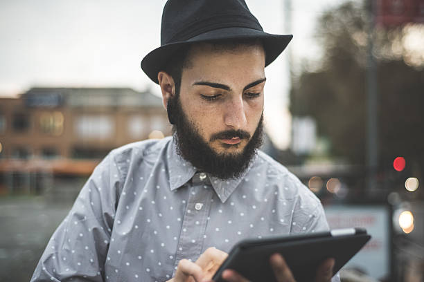 istock young handsome hipster gay modern man using tablet 532410691