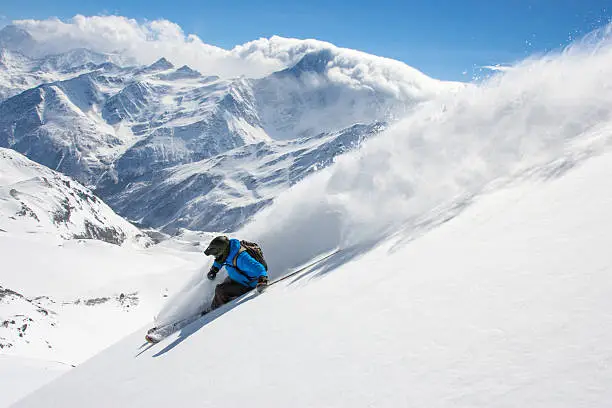 Skier in high mountains during sunny day.Freeride in fresh powder snow,Caucasus mt, Elbrus region.