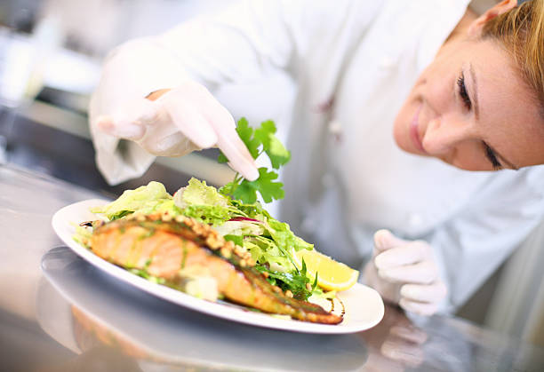 lo chef professionista luoghi tocchi al pasto - prepared fish foto e immagini stock