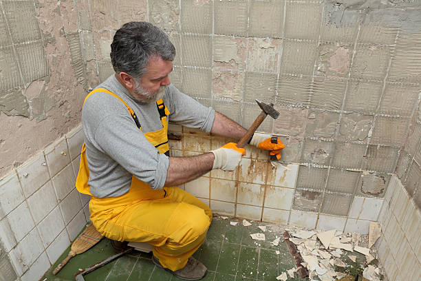 Home renovation, tile demolish Adult worker remove, demolish old tiles in a bathroom with hammer and chisel bathroom remodeling stock pictures, royalty-free photos & images