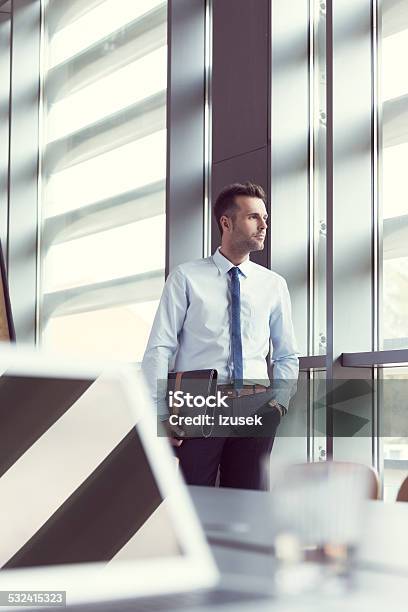 Confident Businessman In Office Holding A Briefcase Stock Photo - Download Image Now