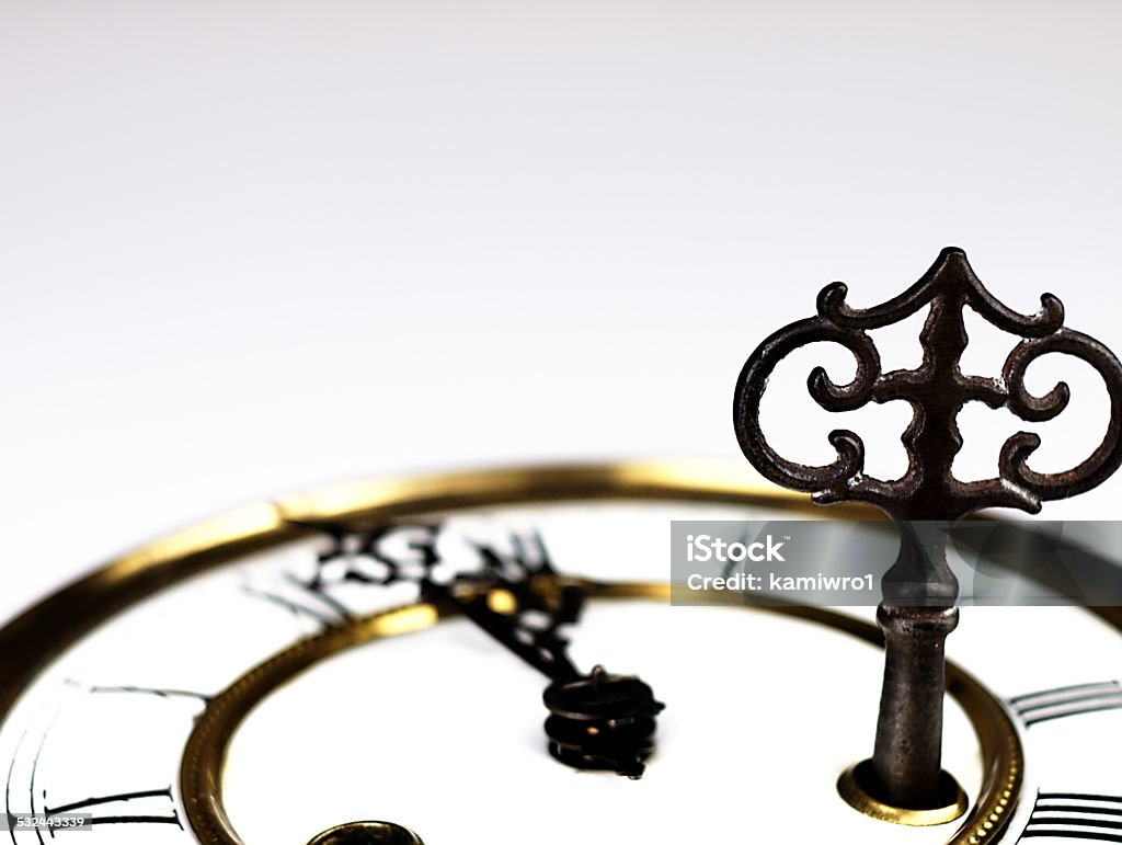 Old clock with roman numerals and key.. Mechanism of old clock. Clock face and hands showing five minutes to midnight. 12 O'Clock Stock Photo