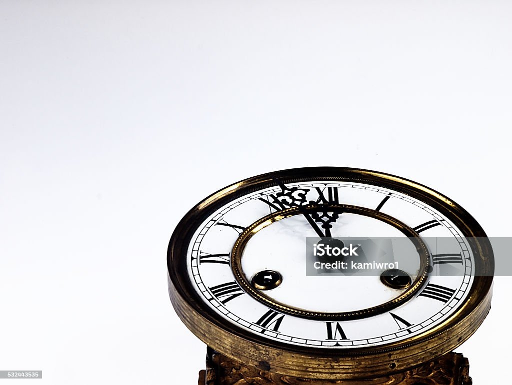 Old clock with roman numerals. Mechanism of old clock. Clock face and hands showing five minutes to midnight. 12 O'Clock Stock Photo