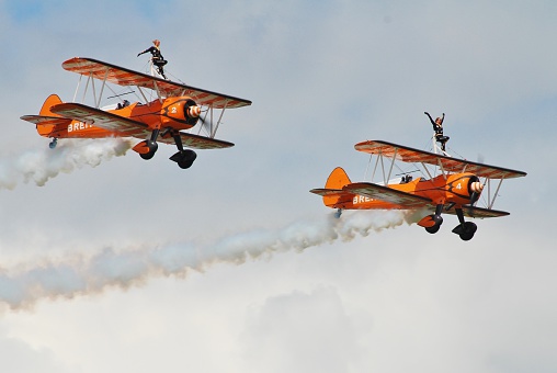 Dunsfold, England - August 23, 2014: The Breitling Wingwalking Display Team perform at the Dunsfold airshow. The team fly 1940s era Boeing Stearman biplanes.