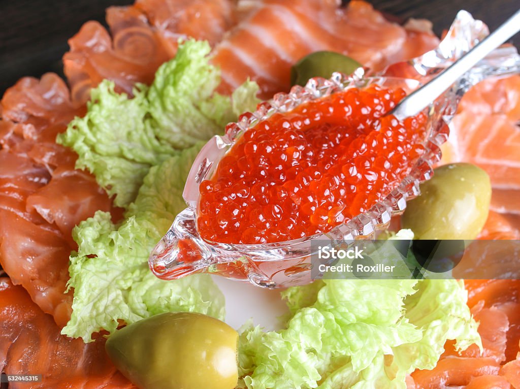 red caviar with salmon and green salad red caviar in a crystal bowl with salmon olives and green salad 2015 Stock Photo