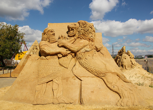 Stock photo showing close-up view of a complex sandcastle built on a sunny, golden sandy beach. Summer holiday, tourism and activities concept.