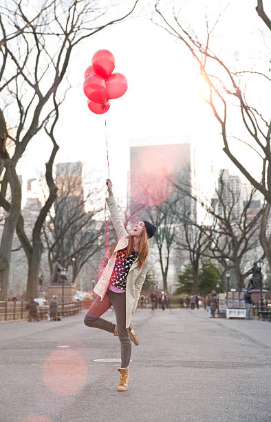 istock Young Woman playfully holding balloons 532447273
