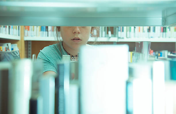 istock Girl between bookshelves 532448299