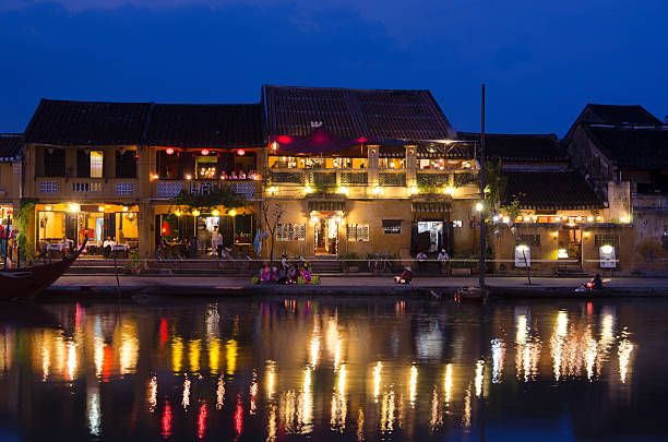 Hoi An, Vietnam at night Evening view of the colourful harbourside houses and boats reflected in the harbour river of the UNESCO World Heritage Site of Hoi An, Vietnam thu bon river stock pictures, royalty-free photos & images