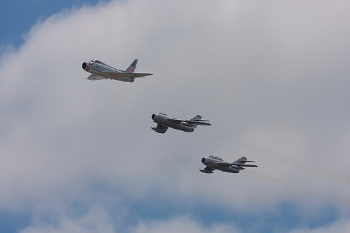 Lakewood, United States - July 17, 2010: Joint Base Lewis-McChord opens its gates to the public for a free airshow every few years.  This image shows a NORTH AMERICAN FJ-4B “FURY” and 2 MiGs in flight over the show. There is only one FJ-4B aircraft left in flying condition in the world.