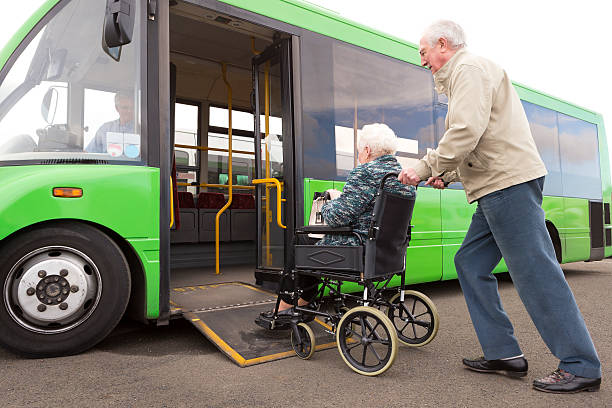 senior pareja contrayendo en autobús a través de la rampa para silla de ruedas - bus door fotografías e imágenes de stock