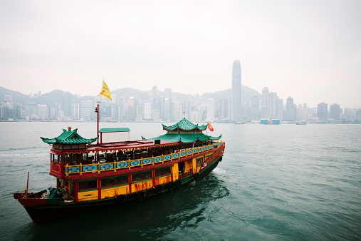 A view of a Chinese Junk boat sailing across Victoria Harbour, Hong Kong. 