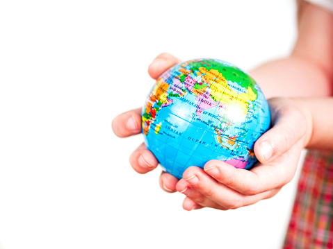 Hands of a child holding a globe on white background