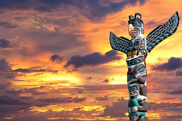 isolated totem wood pole in the gold sunset cloudy background