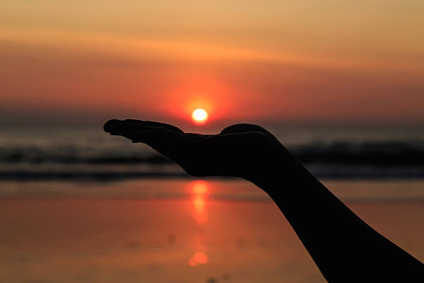 istock Silhouette of hands play with the sun at beach 532482155