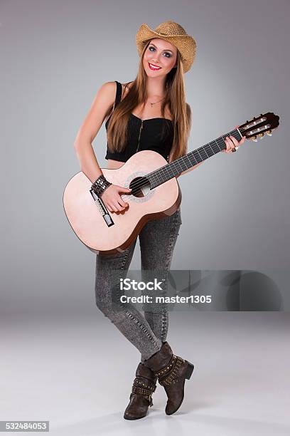 The Beautiful Girl In A Cowboys Hat And Acoustic Stock Photo - Download Image Now - Acoustic Guitar, Acoustic Music, Adult