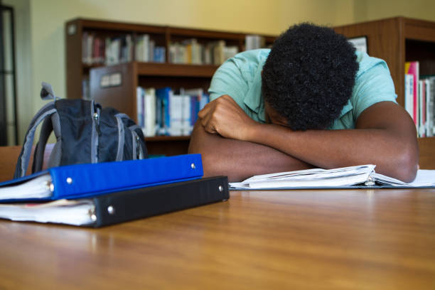 Student overwhelmed with homework African American student overwhelmed with homework defeat stock pictures, royalty-free photos & images