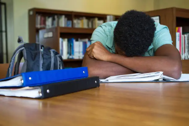 African American student overwhelmed with homework